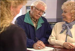 Senior couple reading consents for cataract surgery
