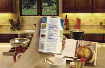 Image of someone holding up a can good where the label is blurry but the background of the kitchen is clear